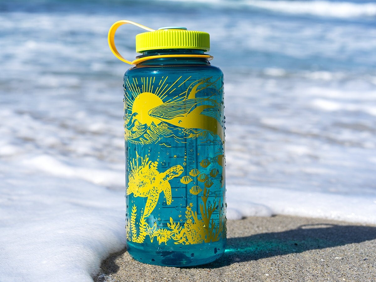 Reusable water bottle on the beach Stock Photo by ©nito103 279147558