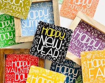 May include: A collection of 10 wooden signs with various holiday and seasonal greetings. The signs are decorated with colorful patterns and white text. The signs include "Happy Back to School", "Happy Summer", "Happy New Year", "Happy Valentine's Day", "Happy Easter", "Happy Spring", "Happy Thanksgiving", "Happy Halloween", "Happy Fourth of July", and "Happy Holidays".