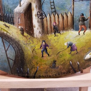 Puede incluir: Una pintura que representa una escena rural con un molino de viento, un puente y varias figuras. Las figuras est&aacute;n vestidas con ropa sencilla y se dedican a diversas actividades, como la agricultura y el paseo. La pintura est&aacute; realizada en un estilo realista con una paleta de colores c&aacute;lidos.