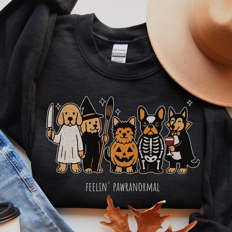 Halloween PNG for download - funny dogs in halloween costumes with quote feelin pawranormal. Halloween-themed graphic of five cartoon dogs dressed in costumes. The dogs are dressed as a ghost, witch, jack-o'-lantern, skeleton, and vampire. The text "FEELIN' PAWRANORMAL" is printed below the dogs.