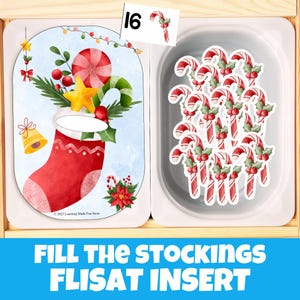 May include: A wooden tray with a Christmas-themed activity. One side features a card with a red stocking, candy cane, and star. The other side holds candy cane stickers. The text "FILL THE STOCKINGS FLISAT INSERT" is at the bottom.