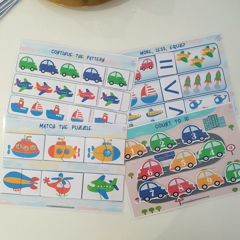 May include: Four colorful printable educational activity sheets for kids featuring transportation themes. The sheets include activities like counting, matching, and comparing quantities. The sheets feature images of cars, airplanes, boats, submarines, and helicopters.