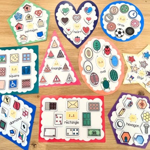 May include: A set of 10 colorful felt shapes with different geometric shapes and names. Each shape has a variety of smaller shapes and images inside. The shapes include a pentagon, heart, circle, square, triangle, oval, star, diamond, rectangle, and hexagon.