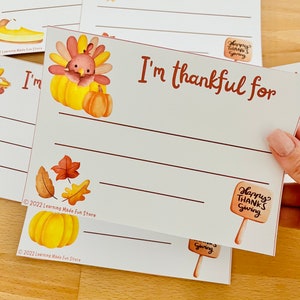 May include: Printable Thanksgiving activity cards featuring a cute cartoon turkey with the text "I'm thankful for" and lines for writing. The cards are decorated with autumn leaves and pumpkins.
