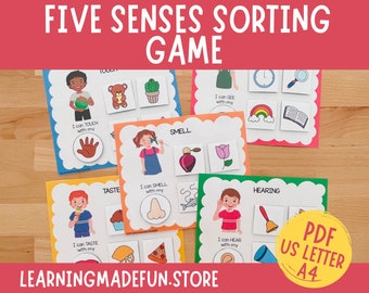Peut inclure: Jeu de tri des cinq sens imprimable pour les enfants. Cartes colorées avec des images d'objets et un enfant se tenant la main au nez, à l'oreille, à l'œil, à la bouche et à la main. Le texte sur les cartes indique "Je peux voir avec mon", "Je peux entendre avec mon", "Je peux sentir avec mon", "Je peux goûter avec mon", et "Je peux toucher avec mon".