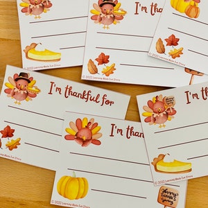 May include: Set of six printable Thanksgiving cards featuring a cartoon turkey with a pie, a pumpkin, and autumn leaves. Each card has a blank space for writing "I'm thankful for..." and a copyright notice at the bottom.