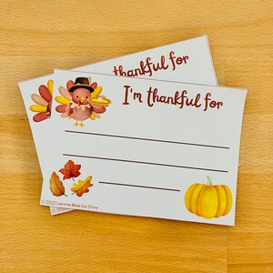 May include: Two white cards with a Thanksgiving theme. The top card says "thankful for" and the bottom card says "I'm thankful for". Both cards feature a turkey illustration and a pumpkin illustration. The cards also have a copyright notice for Learning Made Fun Store.