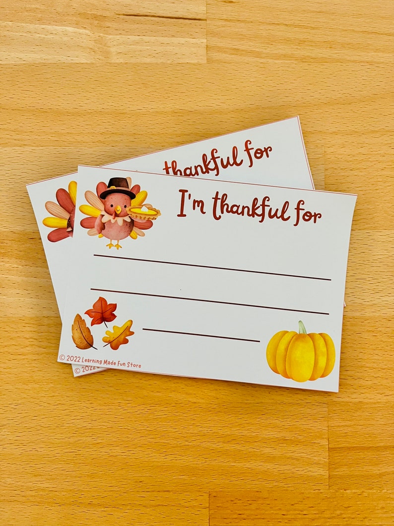 May include: Two white cards with a Thanksgiving theme. The top card says "thankful for" and the bottom card says "I'm thankful for". Both cards feature a turkey illustration and a pumpkin illustration. The cards also have a copyright notice for Learning Made Fun Store.