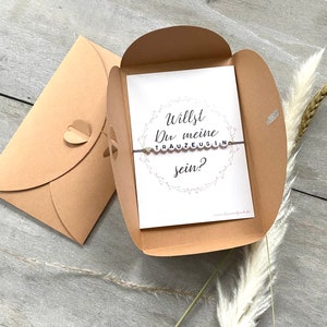 Bracelet et carte de questions pour demoiselle d'honneur dans une enveloppe avec fermoir en forme de cœur