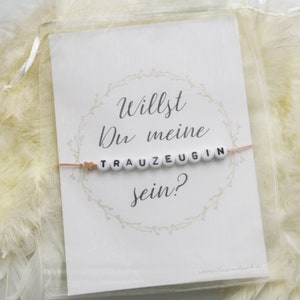 Bracelet et carte de demande de demoiselle d'honneur dans un sac en organza