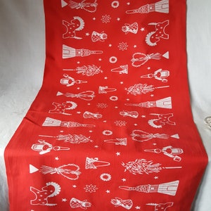 Könnte beinhalten: Ein roter Tischläufer mit einem sich wiederholenden weißen Muster aus verschiedenen Volkskunstmotiven, darunter Engel, Pferde und Blumendesigns. Der Läufer besteht aus einem glatten Stoff und wird wahrscheinlich zu Dekorationszwecken verwendet.