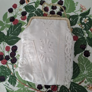 Bolso de mano cosido a mano. Patchwork de lino reutilizado. Piezas bordadas en algodón blanco. Bolso de noche. Marco de metal dorado. Asa de cadena. Sueco.