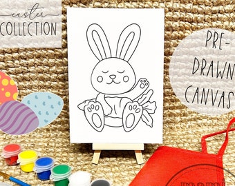 May include: A pre-drawn canvas featuring a bunny with a carrot, displayed on a small easel. The image includes paint pots in various colors, a paintbrush, and a palette. The words "Easter Collection" and "Pre-Drawn Canvas" are visible.