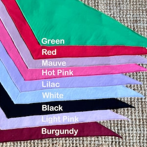 May include: A stack of ten fabric triangles in various colors, including green, red, mauve, hot pink, lilac, white, black, light pink, and burgundy. The fabric triangles are arranged in a fan shape, with the green triangle at the top and the burgundy triangle at the bottom.
