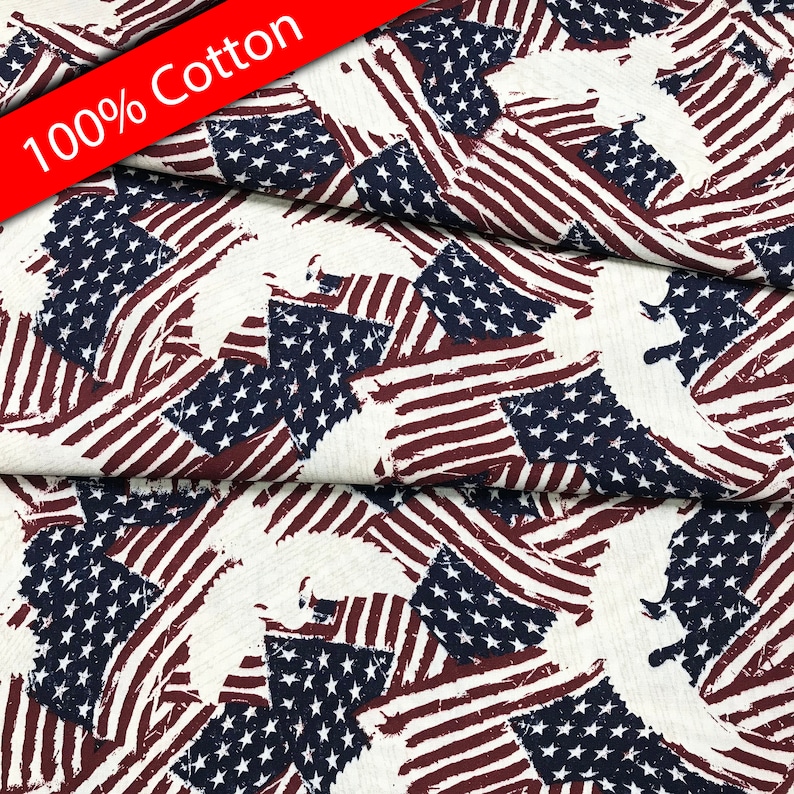 Pu&ograve; includere: Tessuto bianco con una stampa usurata di bandiere americane e aquile. Il tessuto &egrave; 100% cotone.