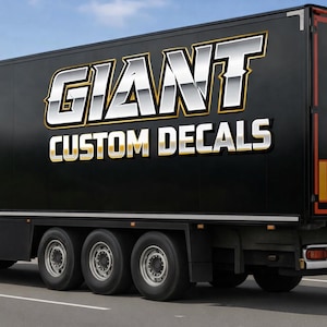May include: Black semi-truck trailer with the words "GIANT CUSTOM DECALS" in large, metallic, 3D lettering. The trailer has three axles with six tires. The background is a blurred sky.