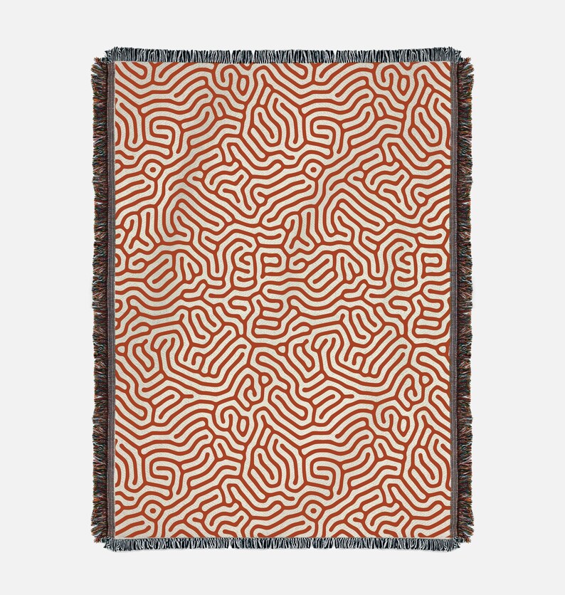 Peut inclure: Une couverture en tissu tiss&eacute; avec un motif abstrait orange rouille et cr&egrave;me. Le motif ressemble &agrave; un labyrinthe ou &agrave; un r&eacute;seau de veines.