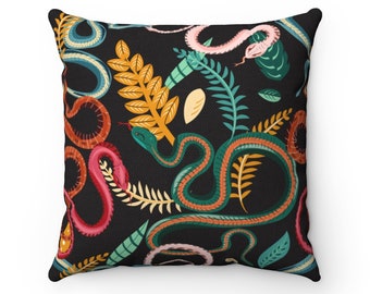 May include: A black throw pillow with a colorful pattern of snakes and leaves. The snakes are green, red, pink, and orange. The leaves are green and yellow.