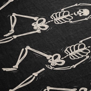 May include: Four white skeletons drawn on a black background. The skeletons are in various poses, some are lying down, some are sitting up, and some are standing.