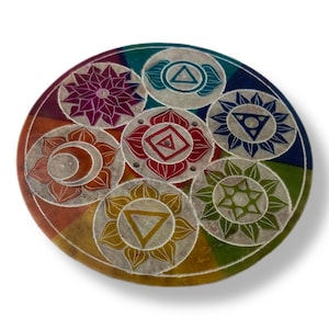 May include: A round, white stone incense burner with seven colourful chakra symbols. The symbols are arranged in a circle and are surrounded by a white border. The burner is approximately 15 cm in diameter.