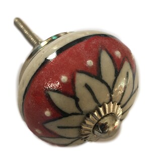 May include: A white ceramic knob with a red and white floral design. The knob has a silver metal base.