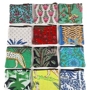May include: A collection of twelve rectangular fabric pouches arranged in a grid, each featuring a unique colourful pattern including floral, animal, and botanical prints, all finished with a black zipper closure along the top edge.