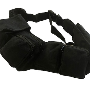 May include: Black canvas fanny pack with multiple zippered pockets and an adjustable strap.
