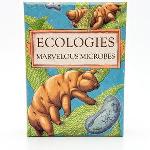 May include: A colorful box featuring illustrations of tardigrades and other microbes. The box has the words "ECOLOGIES MARVELOUS MICROBES" in a rectangular frame. The background is a light blue with green plant-like illustrations.