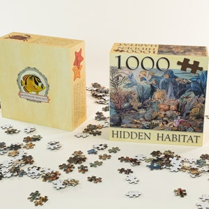 May include: A 1000 piece jigsaw puzzle with a colorful underwater scene. The box features a blue and white butterfly with the text "Montrose Biology" and the title "Hidden Habitat".