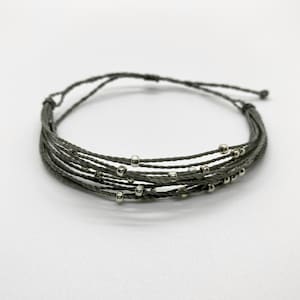 May include: A gray multi-strand bracelet with silver beads.