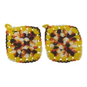 May include: Two square potholders crafted with a crochet granny square pattern. The design features a vibrant color palette of bright yellow, deep brown, white, and orange yarn. Each potholder includes a small corner loop for hanging storage.