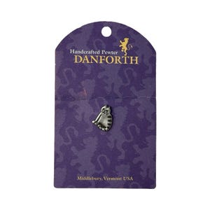 May include: A small, silver-colored pewter cat pin attached to a purple display card. The card features the text Handcrafted Pewter DANFORTH and Middlebury, Vermont USA, along with a gold lion logo. The cat is depicted in a seated position.