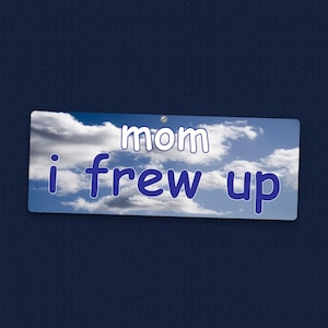 May include: A rectangular sign featuring a blue sky with white clouds background. The text "mom" is printed in white with a dark blue outline, and the text "i frew up" is printed in dark blue with a white outline across the center.