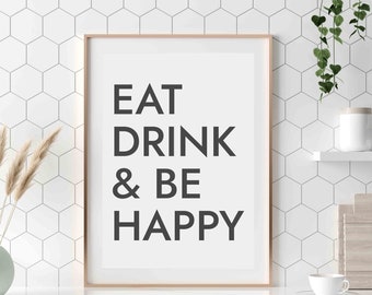 Peut inclure: Une affiche encadrée avec le texte "EAT DRINK & BE HAPPY" en lettres noires sur fond blanc. L'affiche est accrochée à un mur de carreaux hexagonaux blancs dans un décor de cuisine.