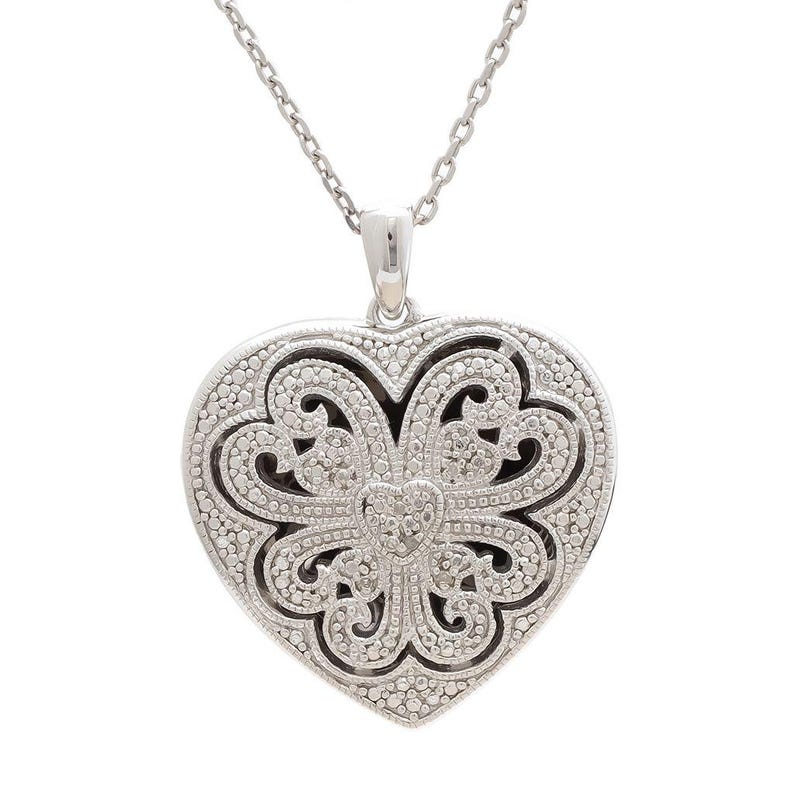 May include: Silver-toned heart pendant necklace. The pendant features an intricate openwork design with a heart-shaped outline and a delicate chain. The heart is embellished with small, sparkling accents, creating a detailed and elegant look.