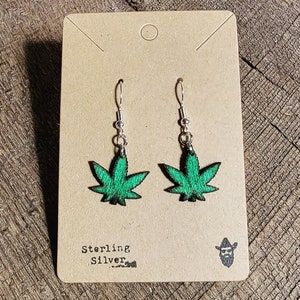 May include: Sterling silver earrings with a green marijuana leaf design.