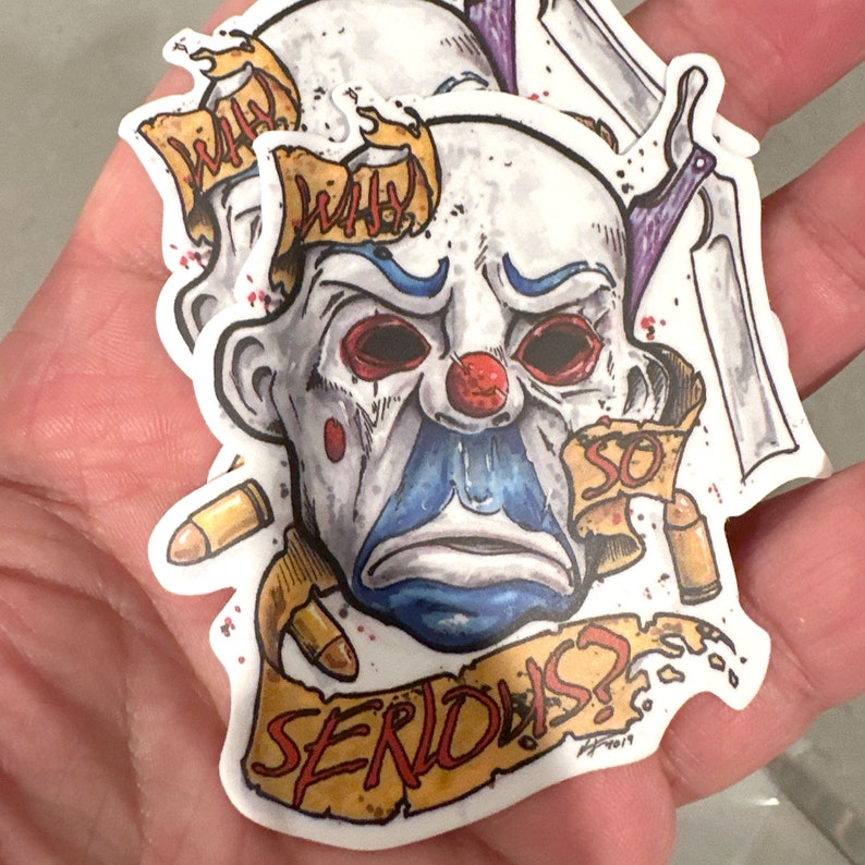 May include: A stack of stickers featuring a clown face with red eyes, a red nose, and blue accents. The stickers have the words "WHY" and "SO SERIOUS?" on them, along with bullet casings and a knife.