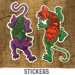 May include: Two die-cut stickers featuring cartoon characters. One sticker depicts a purple panther with green armor. The other sticker shows a green humanoid figure with red armor and a helmet. The word "STICKERS" is printed at the bottom.