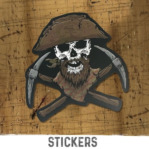 May include: A die-cut sticker featuring a skull with a brown beard wearing a brown tricorn hat, positioned in front of two crossed silver pickaxes with brown handles. The illustration uses a dark color palette with white, brown, and grey tones.