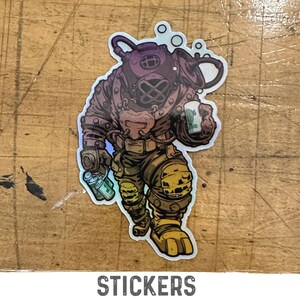 May include: A holographic sticker featuring a cartoon diver wearing a diving suit and holding a can of soda. The diver is wearing a yellow and brown diving suit with a purple helmet. The sticker has a white border.