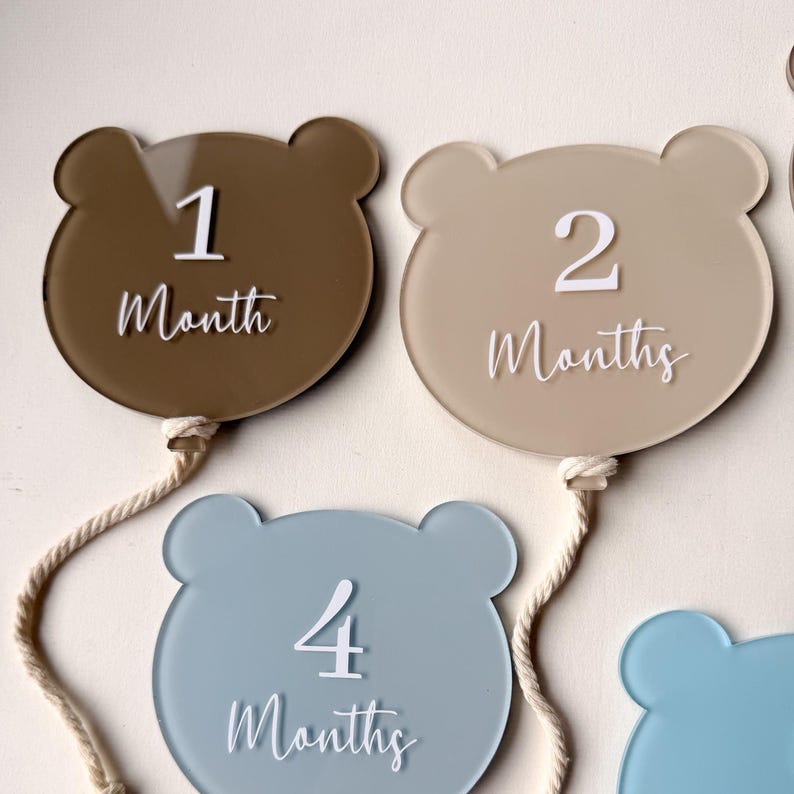 May include: A set of three ceramic mugs with a speckled, matte finish. The mugs are in shades of cream, light gray, and dark gray. Each mug has a simple, minimalist design and a rounded handle.