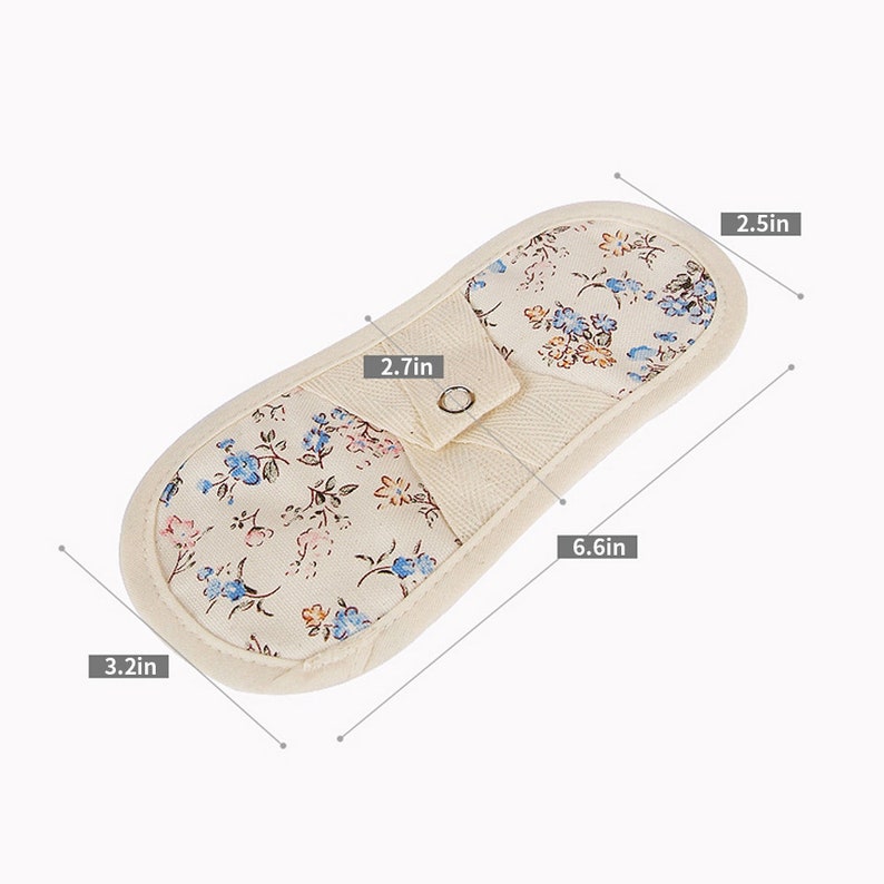 May include: A white cotton pot holder with a floral print in shades of blue, pink, and orange. The pot holder measures 6.6 inches long, 2.7 inches wide, and 3.2 inches high.