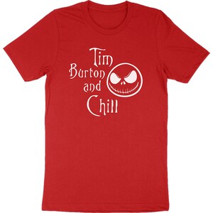Op de afbeelding: Rood T-shirt met de witte tekst "Tim Burton and Chill" en een witte afbeelding van Jack Skellington's gezicht. Het shirt heeft een ronde hals en lijkt gemaakt van een zacht materiaal.