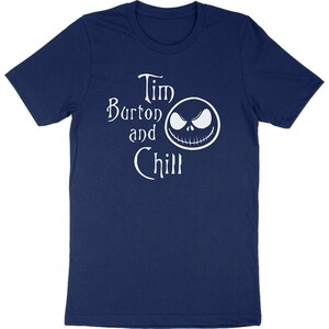 Op de afbeelding: Marineblauw T-shirt met de witte tekst "Tim Burton and Chill" en een witte afbeelding van een gezicht. Het T-shirt heeft een ronde hals.