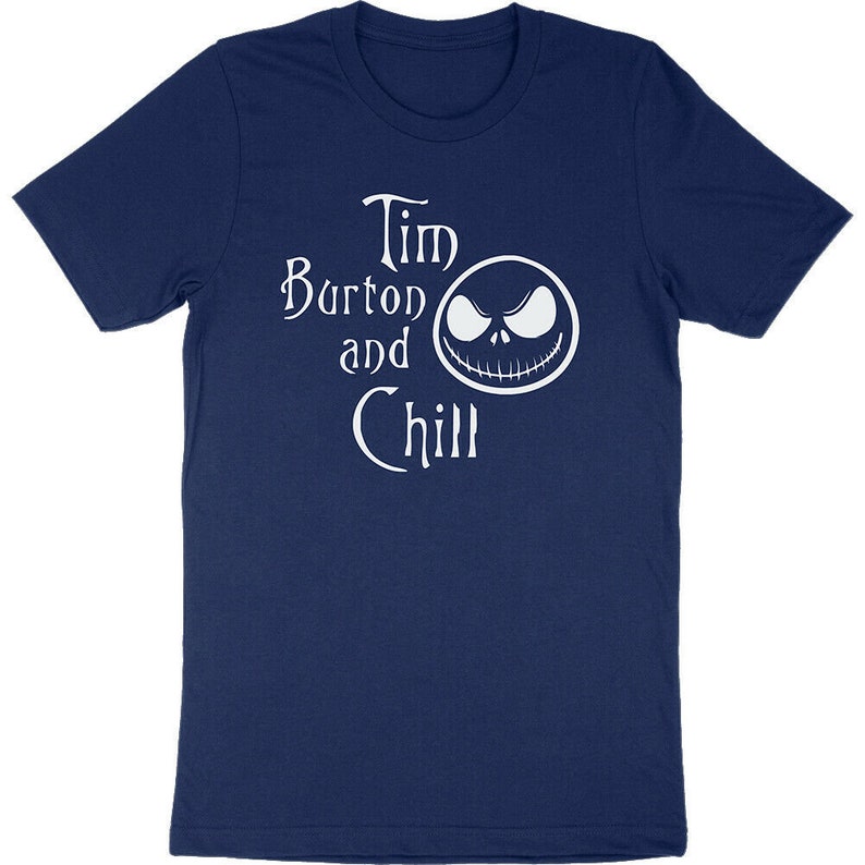 Op de afbeelding: Marineblauw T-shirt met de witte tekst "Tim Burton and Chill" en een witte afbeelding van een gezicht. Het T-shirt heeft een ronde hals.