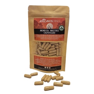 Op de afbeelding: Een bruine papieren zak met een label waarop "AfricanosDrinks Mondia Whitei Capsules" staat. De zak bevat capsules en is omringd door losse capsules. Het label bevat ook de tekst "Bevat een unieke mix van 100% natuurlijke organische verbindingen die mannen en vrouwen helpen. Niet alleen als voedingssupplement voor bloeddrukondersteuning, maar het verhoogt ook de natuurlijke energie en mentale cognitie, wat bewezen is om de bloedvaten te verwijden en de bloedsomloop in het hele lichaam te stimuleren."