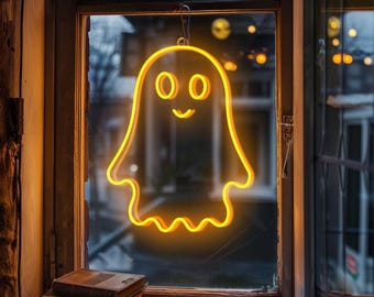 May include: A glowing neon ghost decoration with a friendly face hangs in a window. The ghost is outlined in bright yellow, with a wavy bottom edge. The window frame is wooden, and a stack of books sits on the windowsill.