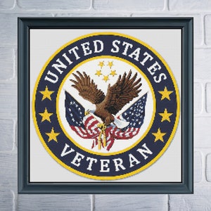 May include: A blue and gold circular emblem with the words "United States Veteran" around the outside. A bald eagle with wings spread is holding a red, white, and blue American flag in its talons. There are five stars in the center of the circle and five stars around the outside of the circle.
