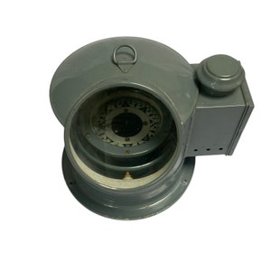 Puede incluir: Una brújula de barco de metal gris con una cubierta de vidrio y una rosa de los vientos en el interior. La brújula está montada en una base con una pequeña perilla en el lateral.