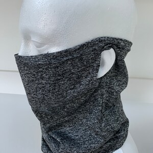 May include: Gray and black neck gaiter with a hole for the ear. The gaiter is made of a soft, stretchy material.